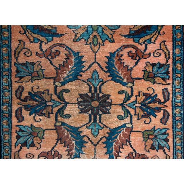 A sweet early 20th century Persian Lilihan rug with a mirrored floral and leaf pattern woven in dark indigo, brick red,...