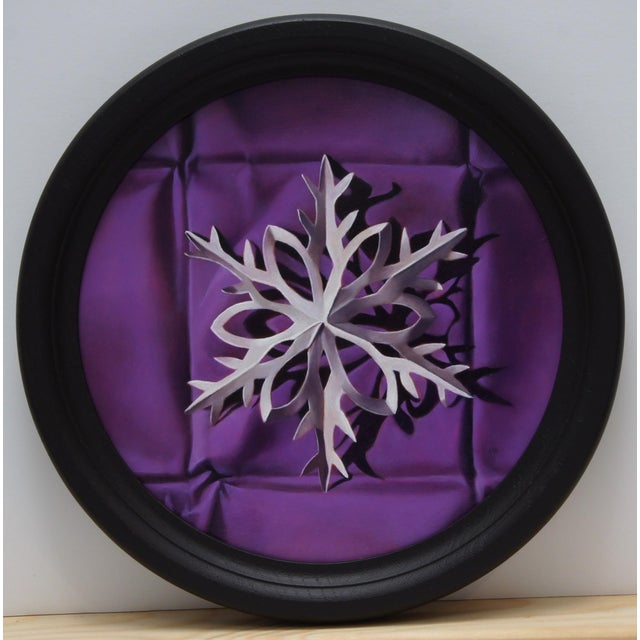 This artwork features a delicate paper snowflake, intricately rendered and positioned against a rich, deep purple...