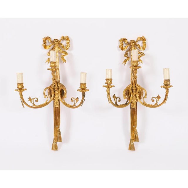 This is a superb antique French set of four antique Louis XVI revival ormolu three-branch wall lights, circa 1870 in date....
