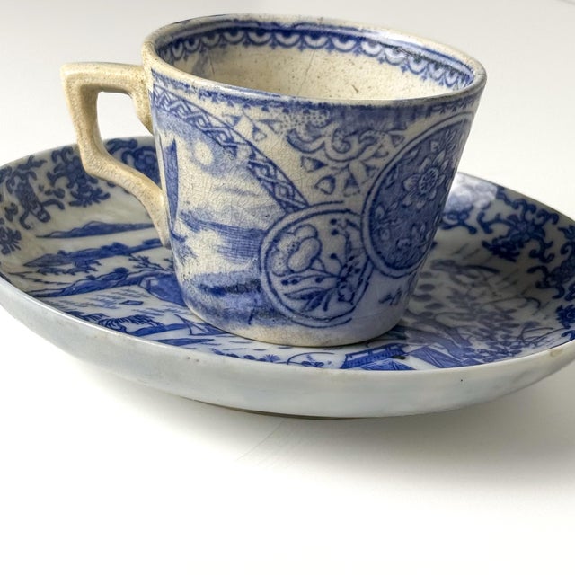 A charming complementary pairing of 18th-century Chinese export blue-and-white porcelain, comprising a small handled cup...