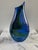 A signed mouth blown art glass vase with a teardrop shape and brilliant blue, green, and purple coloring. Etched Kingwell...