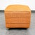 Mid century footstool in orange. Sits on 4 rolling wheels. Unstamped example.