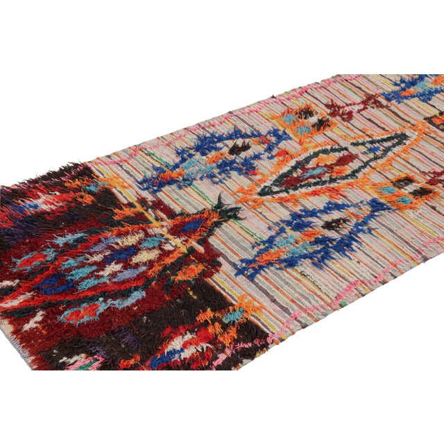 Hand-knotted in wool and originating from Morocco circa 1950-1960, this 3x7 vintage Moroccan rug is an extremely rare...