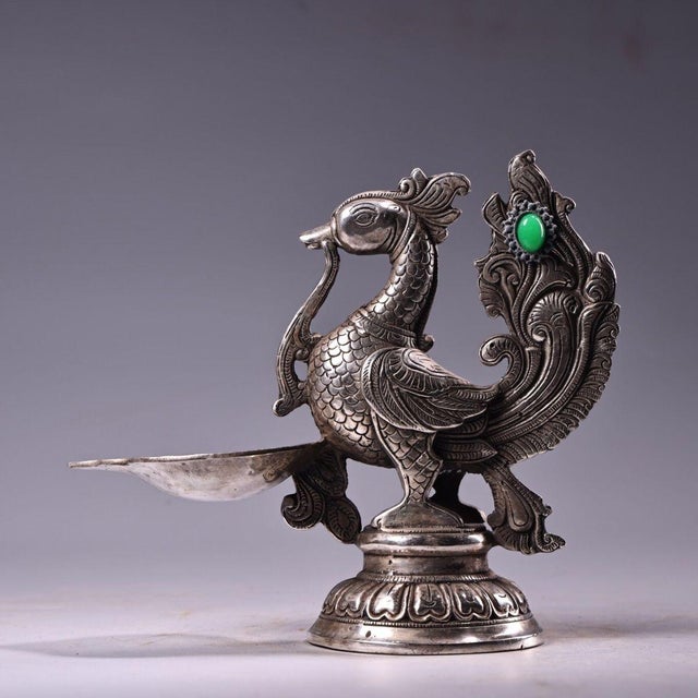 This is an ornate, silver-plated copper oil lamp or figural vessel in the form of a stylized phoenix or mythical bird. The...