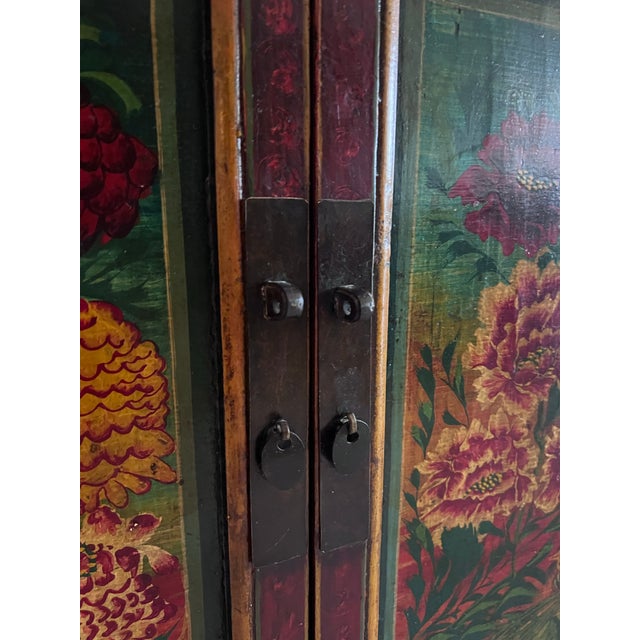 A stunning handcrafted Mongolian buffet cabinet featuring traditional painted motifs and intricate detailing. This piece...