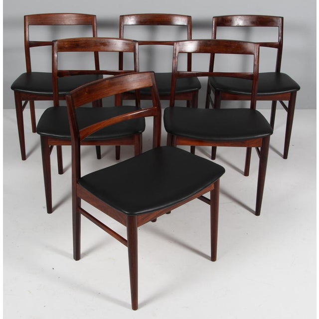 Henning Kjærnulf six dining chairs, new upholstered with black full grain aniline leather. Frame of solid rosewood. Made...