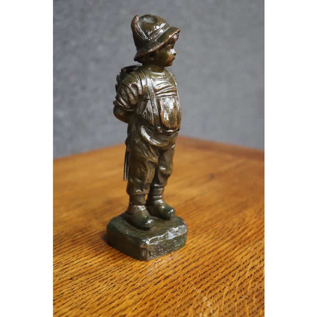 Charming early 20th-century bronze figure of a young boy dressed in a traditional Alpine or European country costume,...