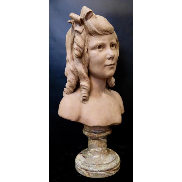 This wonderful vintage early 20th century terra cotta sculpture is of the head of a young girl with a ribbon in her curled...