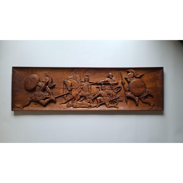 A unique, large wall relief, handcrafted from solid wood, depicting a dynamic scene inspired by the Trojan War—armed...