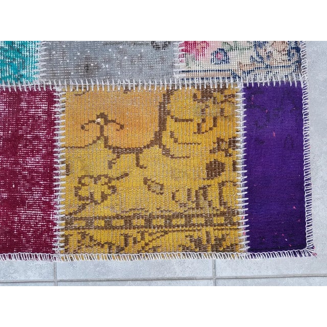 This is a vintage Turkish Oushak rug from the Mid 20th Century. The piece was hand-knotted.