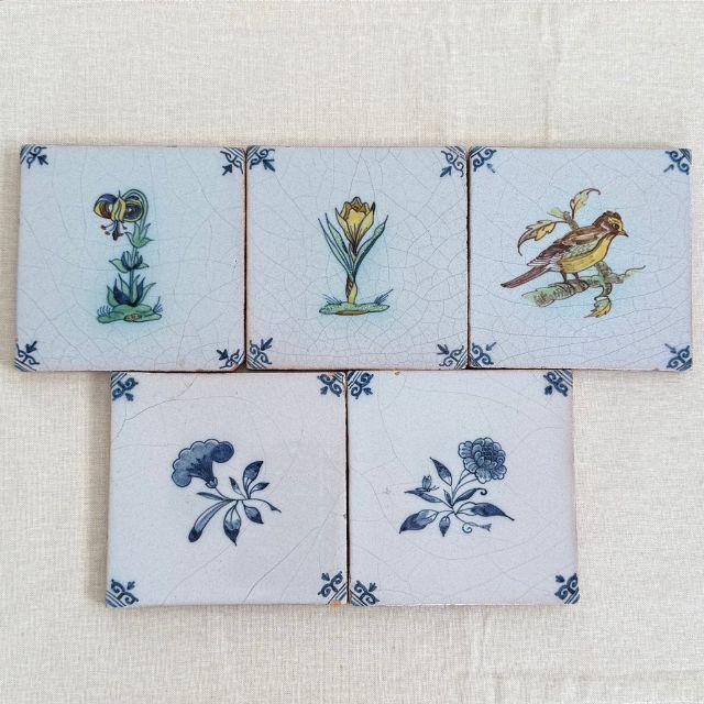 A gorgeous set of five (5) 19th-century Dutch Delft tiles with flowers and a bird. Two (2) tiles have flowers with color...