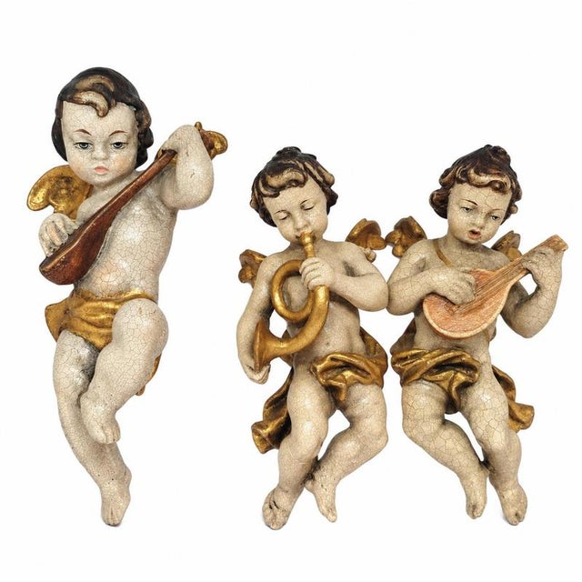 Set of three musical angels in wood. Identification: set composed of three wall-mounted musical angels: one larger figure...