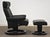 A modern black leather reclining lounge chair and ottoman made by Ekornes Stressless. Seat height is 16”. Ottoman is...