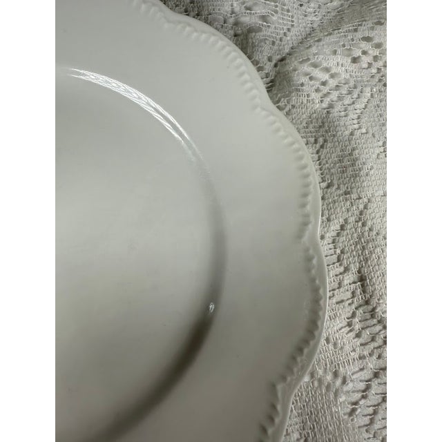 Elevate your table setting with this elegant Haviland France white porcelain plate, featuring a classic scalloped edge and...