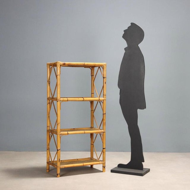 Vintage bookcase with bamboo frame and four open wicker shelves. This piece is attributed to the mentioned designer/maker....