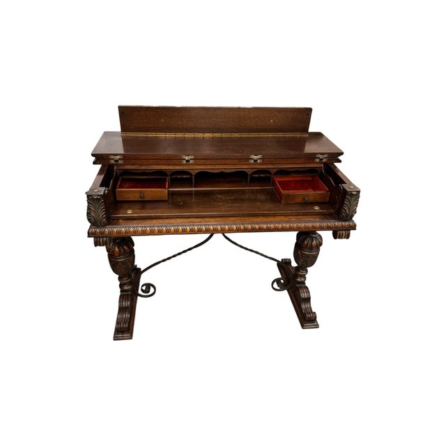 A beautifully crafted vintage flip-top writing desk featuring rich wood grain, ornate carved detailing, and classic...