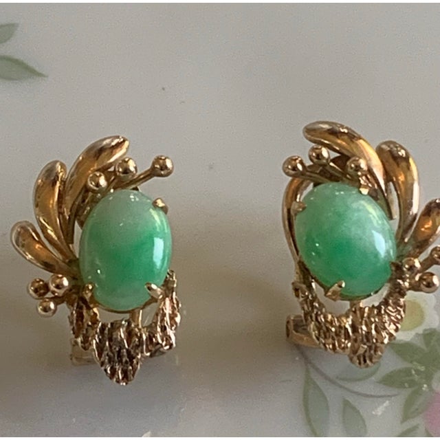 Elegant vintage earrings crafted in 14K yellow gold and set with beautiful oval green jade cabochons. The jade stones...