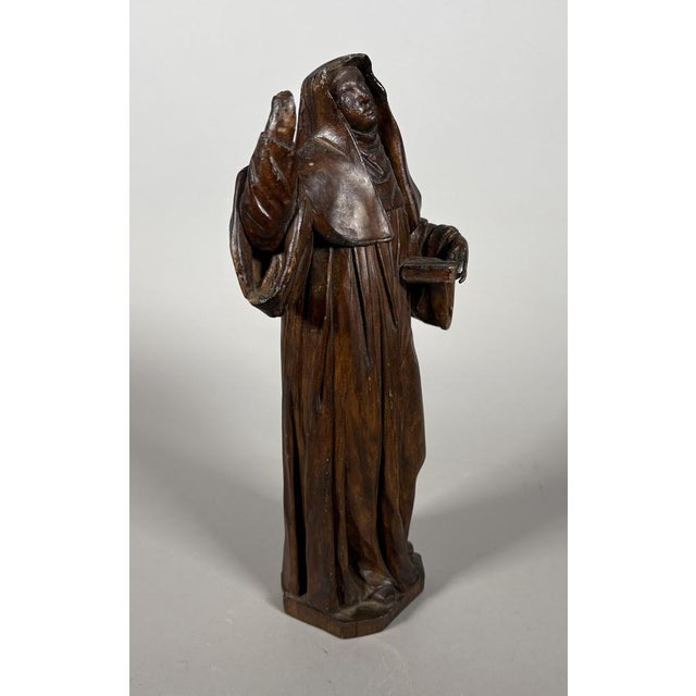 Saint Anne or Saint Bridget, carved wood with a brown patina French work, 17th century She is depicted with one hand...