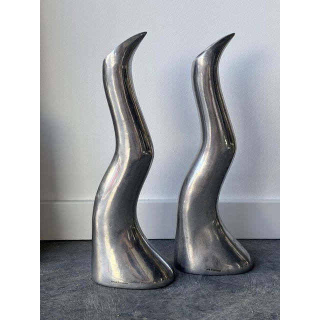 Crafted from solid cast aluminum, these candlesticks captivate with their fluid, organic lines, evoking two silhouettes or...