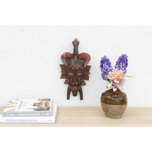 This striking mask, with its bold geometric patterns and avian-inspired design, speaks of a rich cultural heritage and...