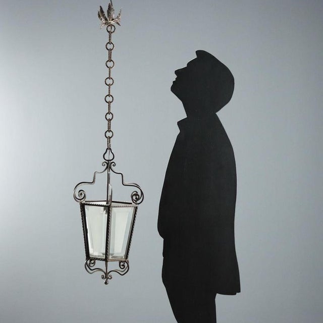 A pair of wrought iron lanterns featuring a truncated pyramid-shaped hexagonal structure, enriched with curlicue and...