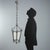 A pair of wrought iron lanterns featuring a truncated pyramid-shaped hexagonal structure, enriched with curlicue and...