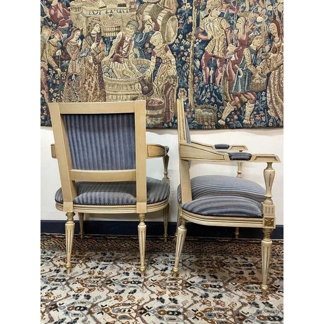 Charming pair of vintage French armchairs in the Louis XV style, upholstered in a blue striped fabric. The carved frames...