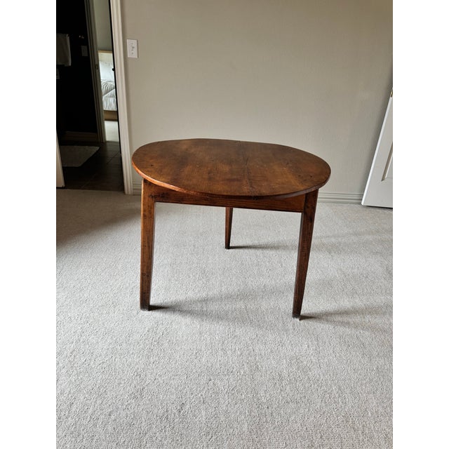 Early 20th Century round table made of dark-stained hardwood with a rich, warm patina and visible grain.