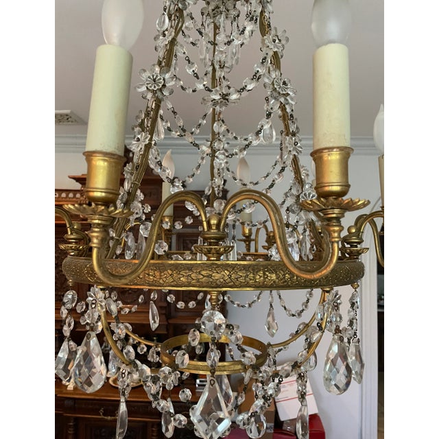 Exceptional 20th century Empire brass and crystal basket chandelier with 10 lights. The top has a waterfall of crystals...