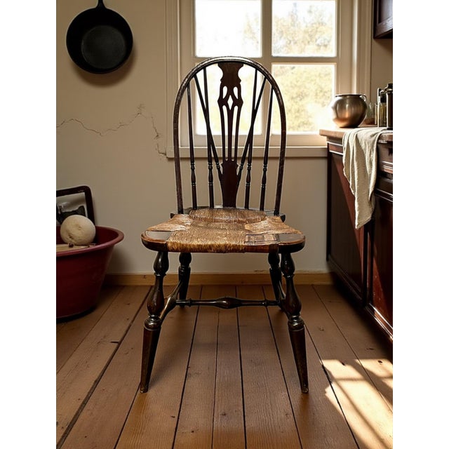 A charming 19th-century Windsor side chair featuring a beautifully arched spindle back with a pierced splat, turned legs,...