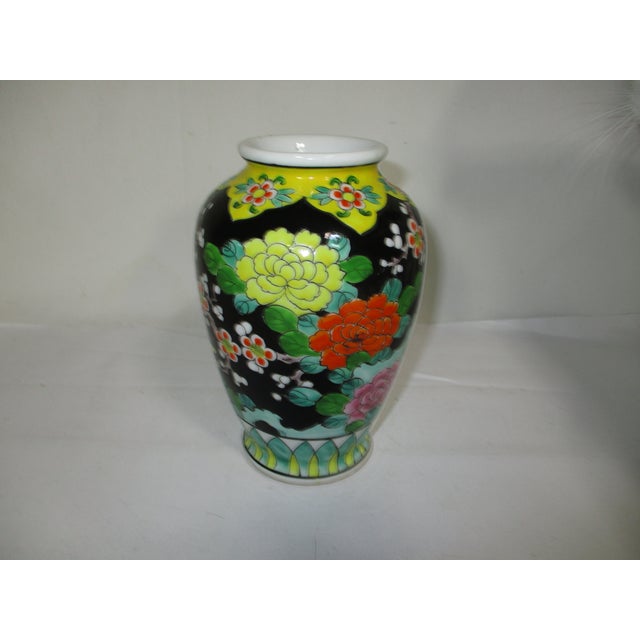 A vintage colorful Japanese hand-painted porcelain vase. It is decorated with peacocks perched on a branch of cherry...