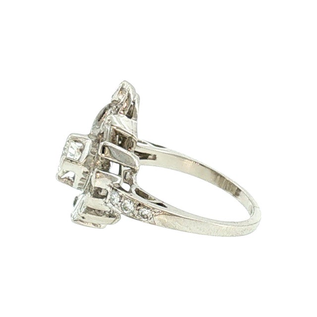 1940s retro platinum and diamond cocktail ring. The ring features an approximately 0.35 carat brilliant cut diamond, white...