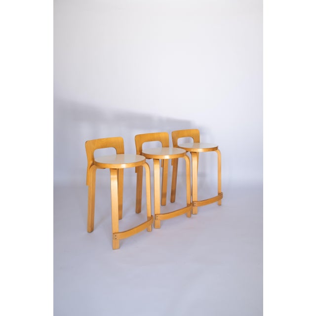 Three stools, model k65. Artek, finland, 1970. wood and laminate structure. Original label. good condition with minor...