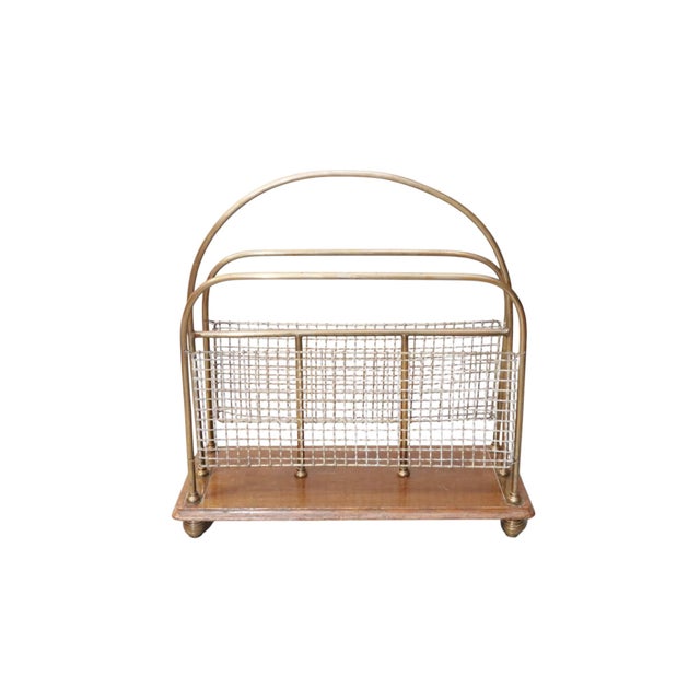 An Edwardian period English magazine rack. A beveled oak base with the brass and wire mesh dividers is raised on turned...
