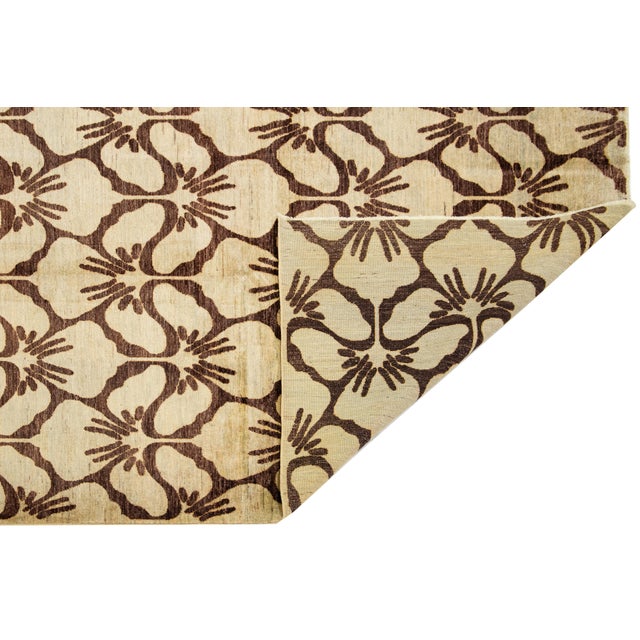 Hand-knotted Peshawar wool rug featuring a grid of stylized floral medallions in dark brown over a soft beige field. The...