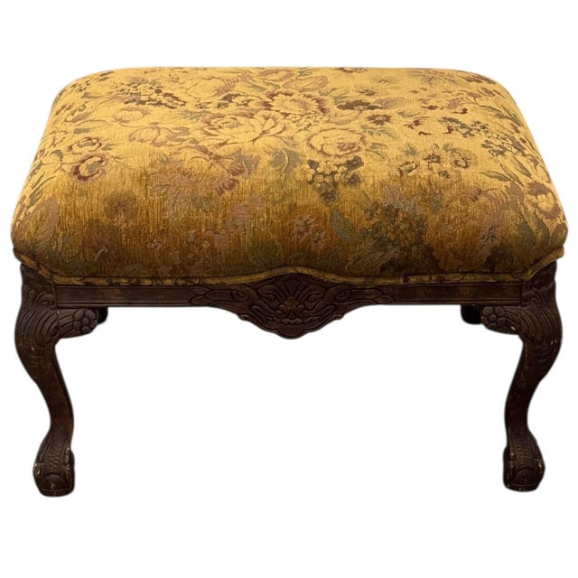 An antique carved wood stool featuring tapestry upholstery and cabriole legs. 29” wide 22” deep 18.5” tall