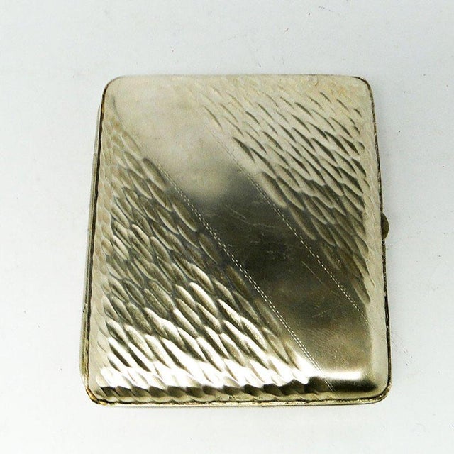 The cigarette case was made by Roman Plewkiewicz's factory in Polish in the 20s. Cigarette case made of clad brass. It has...