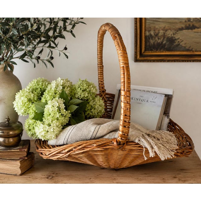 This beautiful oversized gathering basket has a warm honey-toned patina and sculptural woven handle that gives it...