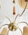 This mid-century chandelier, likely from France, features a brass frame and six arms. Elegant shades are positioned...