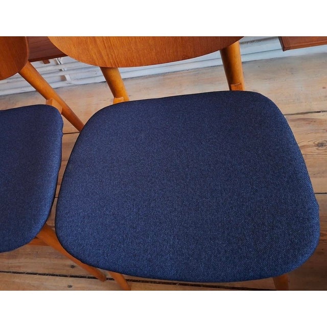 Finely constructed pair of Danish dining chairs in teak and beech, seats recently re-covered with a structured navy blue...