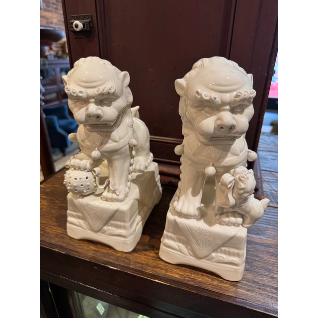 Fine vintage pair of 20th century ceramic Blanc de Chine Foo dogs. Unmarked. Highly detailed: the tiny ceramic balls,...
