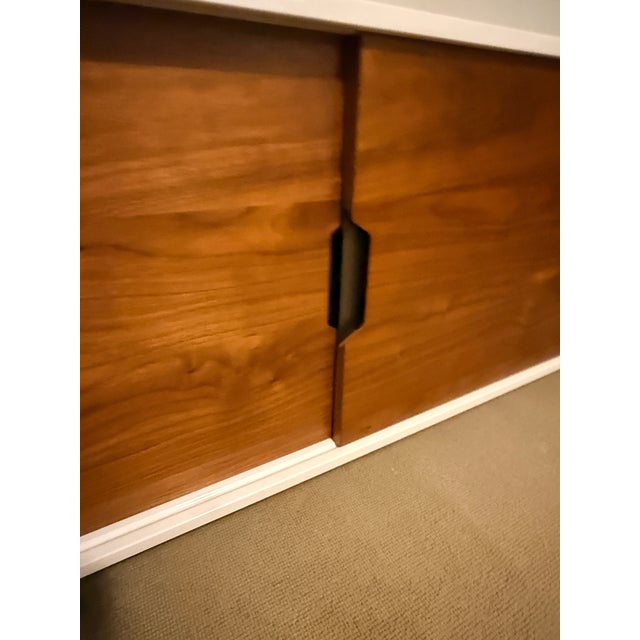 Four Hands Large Tucker Media Console White high-gloss lacquer with brown walnut for contrast. The unit has drawers and...