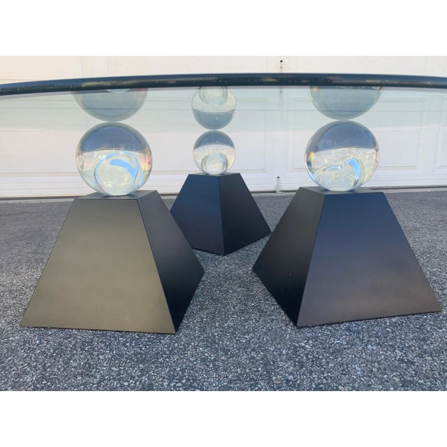 This is an amazing vintage sculptural coffee table. Heavy round glass supported by 3 solid lucite globes on a pyramid....