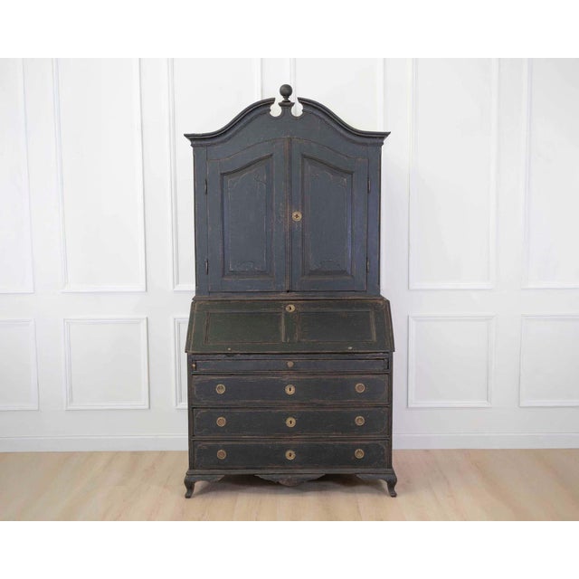 Made in Scandinavia around 1790, this bureau has a black painted finish and very fine carvings. The bureau, a sloping-...