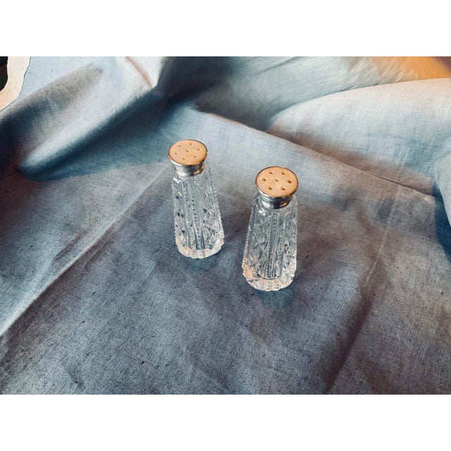 Elaborately cut Crystal Salt / pepper shakers with Sterling silver and mother of pearl tops. Quite old and purchased from...