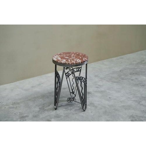 An exceptional art deco side table in hand wrought and worked iron with a richly figured red and white marble top. Europe,...
