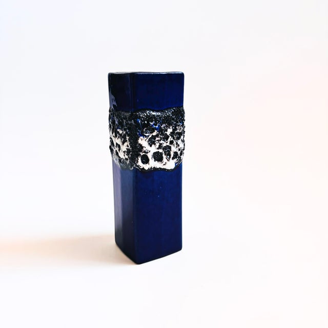 A mid century German pottery bud vase. Blue base glaze with wonderful textured gray and black lava glaze detailing to the...