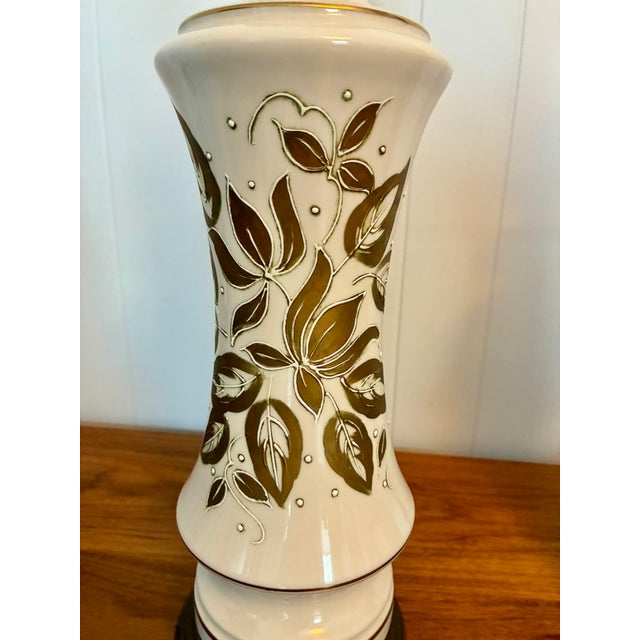 MCM /Hollywood Regency style pair of white porcelain lamps with hand painted gold leaf and patinated brass bases.