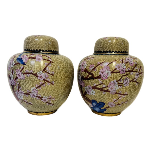 Pair of Vintage Chinese Cloisonné Ginger Jars Featuring Intricate Enameled Bird and Floral Designs on a Patterned Beige Background. For Sale