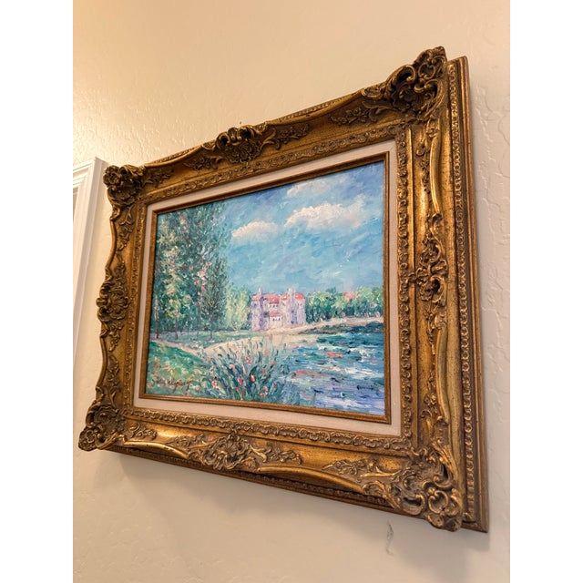 Beautiful vintage impressionist oil-on-canvas landscape featuring a waterfront estate surrounded by trees, flowers, and...